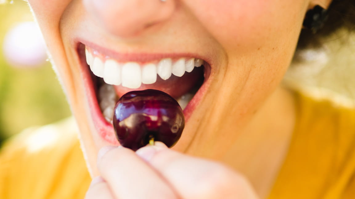 Una mujer comiendo cereza