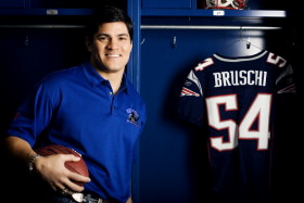 Tedy Bruschi holding a football