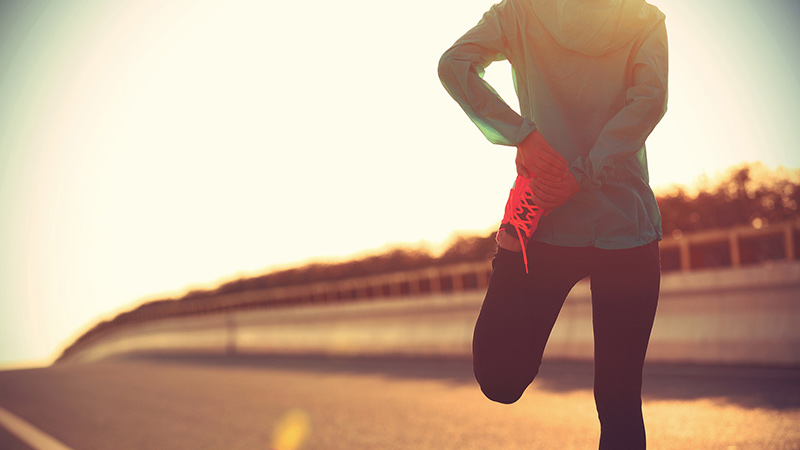 Mujer haciendo estiramientos al aire libre durante tu entrenamiento