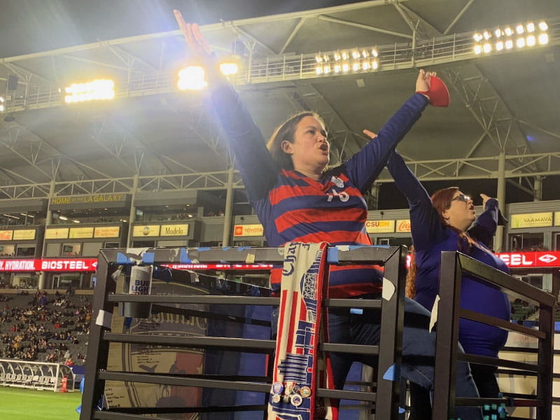 Crystal Cuadra-Cutler (left) leads fans in the stands in a chant during a soccer game in Carson, California, in 2021. (Photo courtesy of Rob Hendricks)