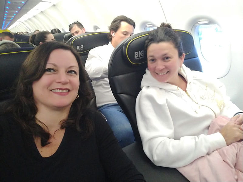 Monica (left) and Ximena enjoy their first‑class flight from Boston to Orlando, staying awake the whole trip.
