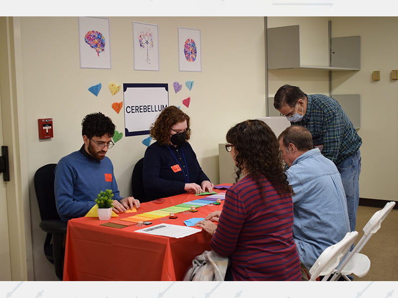 Research techs at the Framingham Heart Study demonstrate a digital health station to visitors during the center’s 75th‑anniversary open house.