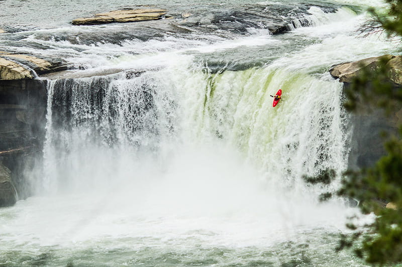 Nick Troutman paddling over the waterfall in his kayak at Cumberland Falls in Kentucky