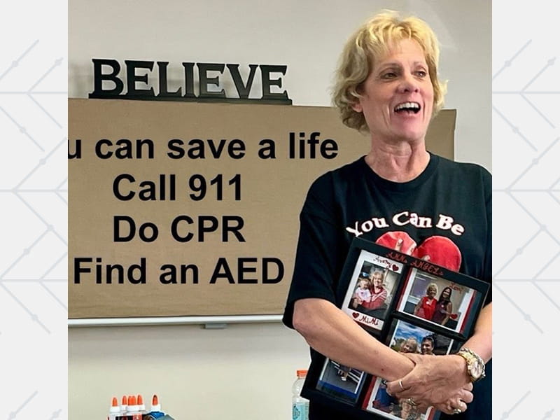 Ann holds up a T‑shirt she designed for her Heart Run and Walk team, ‘Ann’s Angels.