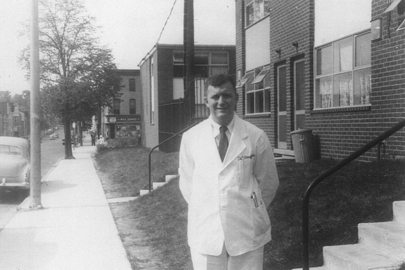 An old photo of Eugene Braunwald standing on a sidewalk.