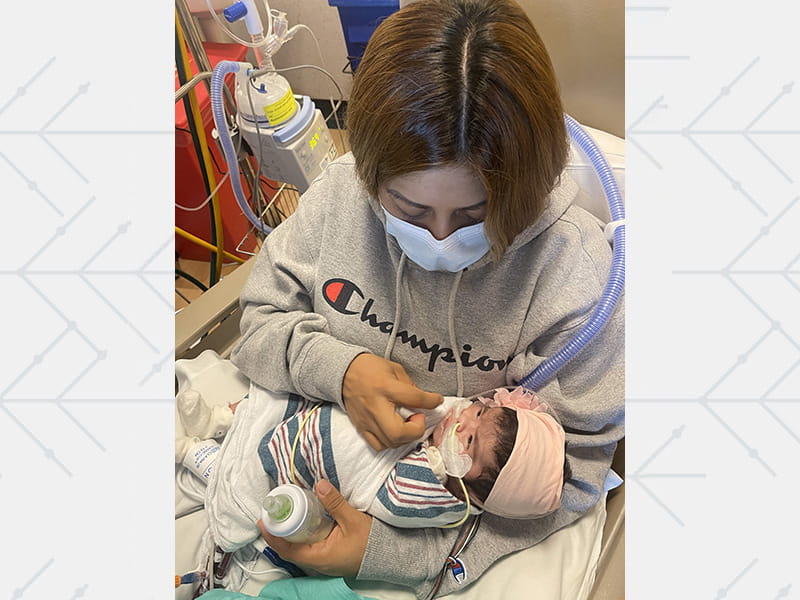 Aaliyah's mother, Michelle, feeding her in the hospital room