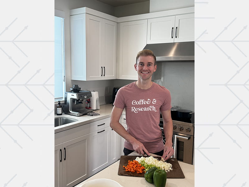 Dr. Matthew Landry chopping vegetables in the kitchen