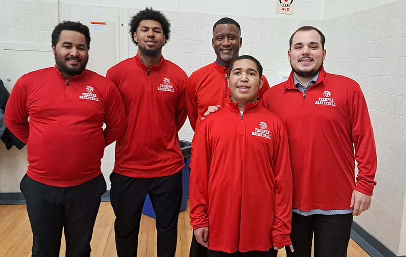 Manny Rios with teammates and coaches wearing red on National Wear Red Day in 2025