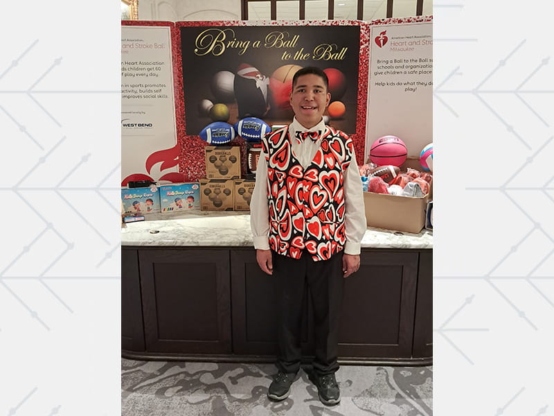 Manny Rios standing in front of his sports equipment drive at the annual Heart Ball in Milwaukee