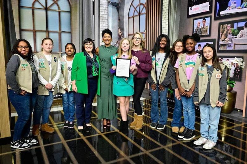 Vada, holding a letter about her Medal of Honor, and Amanda (maroon sweater), with Tamron Hall (green dress), a Girl Scouts executive (green jacket), and other Girl Scouts Medal of Honor recipients on the set of the Tamron Hall Show.  (Tamron Hall Show photo courtesy of Carawan family)