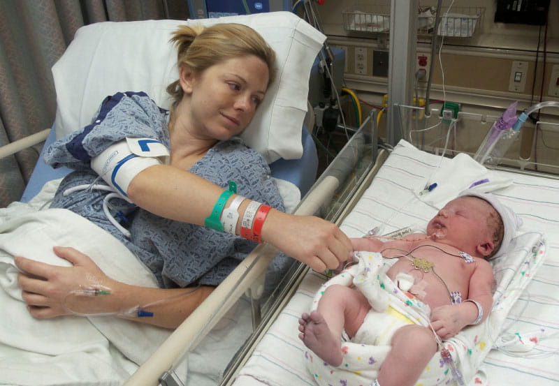 A nurse wheeled Jamie into the NICU so she could touch Jackson for the first time. The blue tint of his right foot is a sign of the heart problems he was born with. (Photo courtesy of the Dawson family)