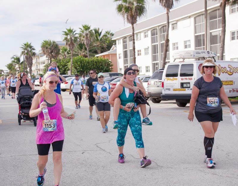 Kandi Schmitz felt lightheaded near the finish line of the 5K she and her friends ran together in 2015. From left: Jennifer Cabrera, Kayla Cabrera giving Kandi a piggyback ride, and Karin Cabrera. (Photo courtesy of Kandi Schmitz)