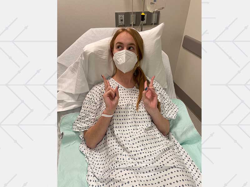 Liv Pines in hospital bed looking cheerful