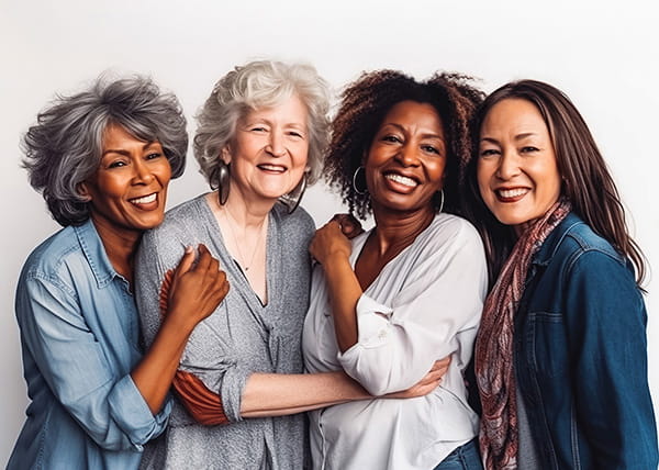 Four older women posing together and smiling