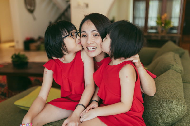 Mom on sofa with her two daughters