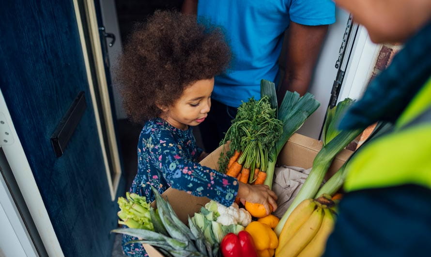 Father and daughter receiving a delivery of fresh produce