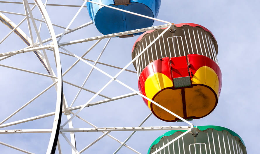 Looking up at part of a large Ferris wheel with colorful cabins