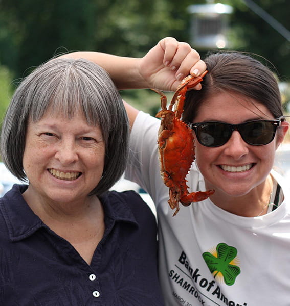Anna Baniak holding up a crab, with her mother, Marian Cappello
