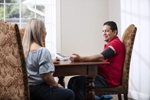 Man checking blood pressure at dining room table