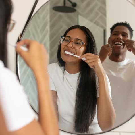 Couple brushing and flossing together