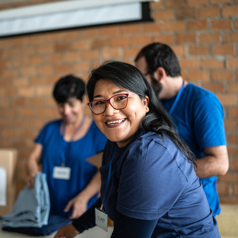 Smiling volunteers sorting donations in a warehouse
