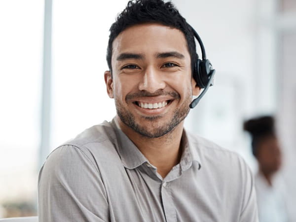 Professional wearing a polo and a headset smiling