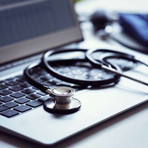 close up of a stethoscope on top of an open laptop keyboard