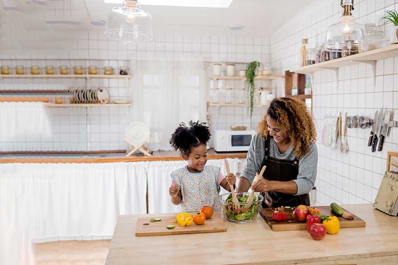 Mom and young daughter cooking
