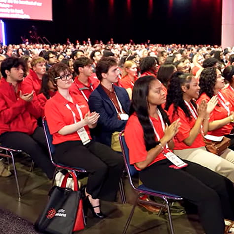 American Heart Association Scholars are sitting in the audience at a Scientific Sessions presentation and clapping.
