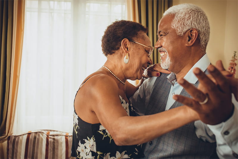 older black couple dancing close together in the living room