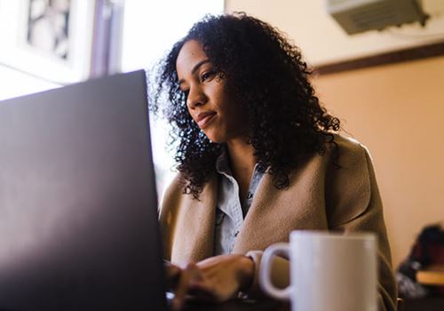 a woman working on a laptop in a coffee shop