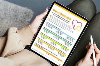 close up view of a woman's hands holding a tablet, taking a self-assessment online