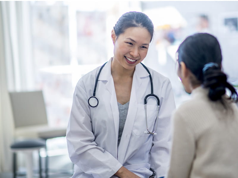 smiling doctor speaking to a patient in an office